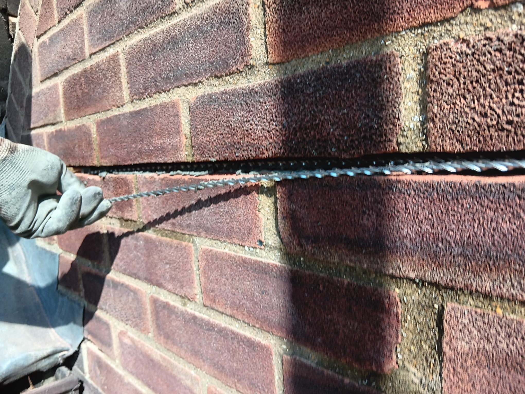 Brickwork joint being repointed by hand